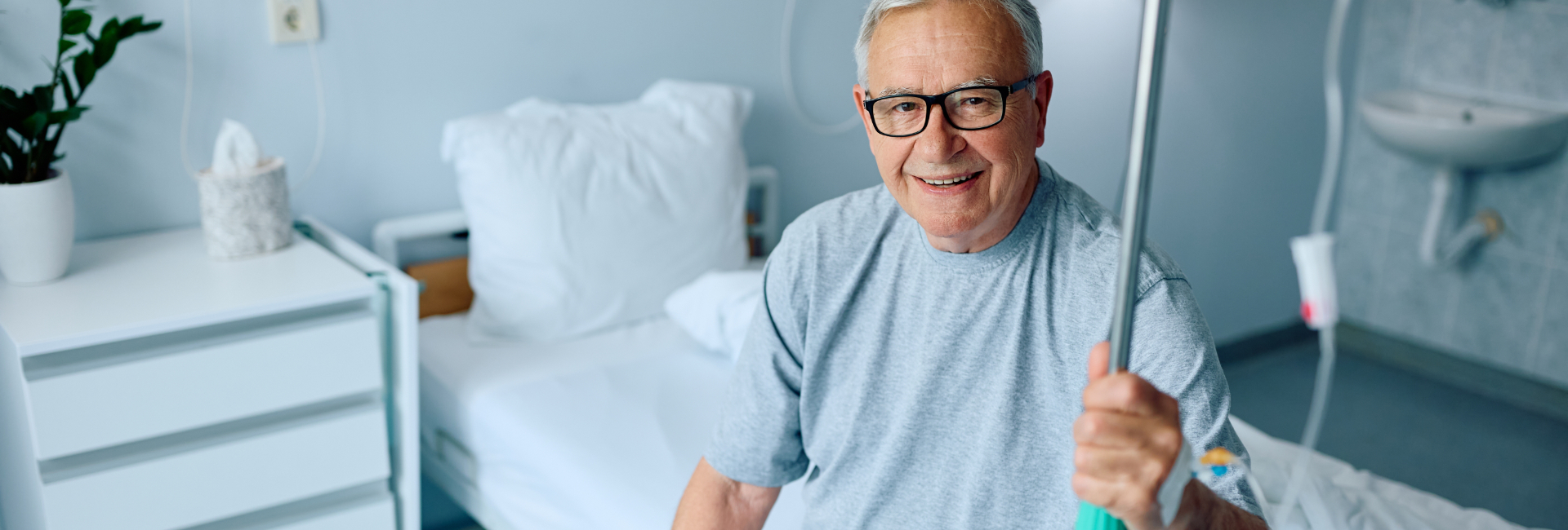 Male Patient Sitting On Hospital Bed 1920X650